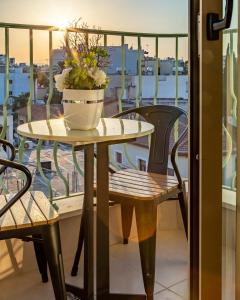 uma mesa com um vaso de plantas numa varanda em Leonardo Boutique Hotel Larnaca em Larnaka