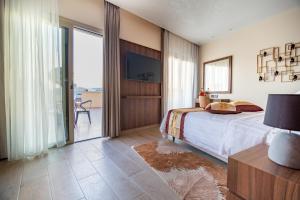 a bedroom with a bed and a sliding glass door at Leonardo Boutique Hotel Larnaca in Larnaca