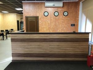 a reception counter with clocks on a wall at HOTEL CITY M in Saratov