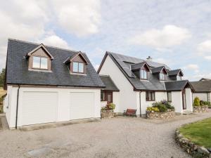 a house with two garages and a driveway at Burnside in Lairg