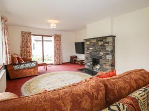 a living room with a couch and a fireplace at Burnside in Lairg