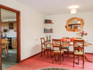 een keuken en eetkamer met een tafel en stoelen bij Burnside in Lairg