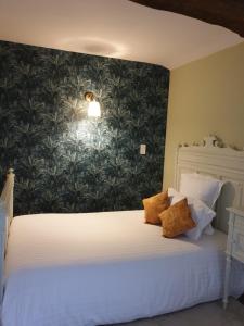 1 dormitorio con cama blanca y pared verde en Domaine de Bourgville, en Monts-sur-Guesnes