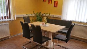 comedor con mesa de madera y sillas negras en Ferienwohnung Corinna, en Fehring