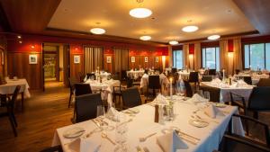 uma sala de jantar com mesas e cadeiras brancas em Hotel Gude em Kassel