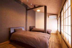 京都市にあるKuromon Houseの窓が2つある部屋にベッドが2つある