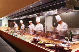 un gruppo di chef in una cucina che prepara il cibo di Ooedo Onsen Monogatari Hotel Suiyotei ad Atami