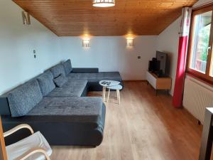 a living room with a couch and a table at Chalet Les Chardons in Gérardmer