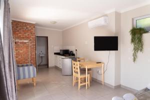 a living room with a table and a kitchen at One One Five Albrecht Street in Bloemfontein