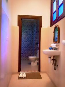 uma casa de banho com um lavatório e um WC em DAR AZIZ em Marrakech