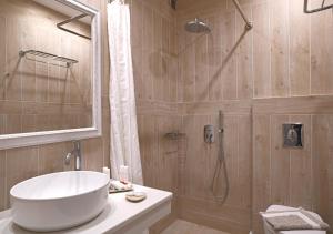 a bathroom with a tub and a sink and a shower at Erato Hotel Mykonos in Ornos