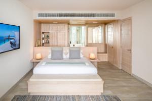 a bedroom with a large bed and a large window at Nurai Island Resort in Abu Dhabi