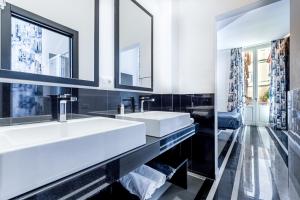 a bathroom with two sinks and a large mirror at V-Accommodation IV Fontane in Rome