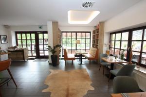 um restaurante com mesas e cadeiras e um tapete no chão em zeitlos Hotel und Restaurant am Fuchsbach em Pattensen