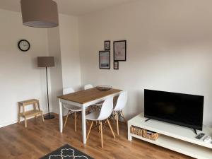 a dining room with a table and a television at FeWo Oberwiesenthal in Kurort Oberwiesenthal
