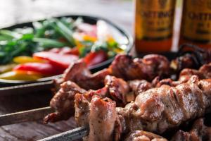 a grill with meat and a plate of food at Foresta Festival Park in Prokhorovo