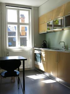 uma cozinha com uma mesa e um lavatório e duas janelas em ApartmentInCopenhagen Apartment 1143 em Copenhague