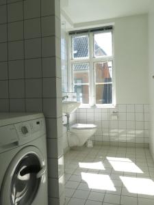 ein weißes Badezimmer mit einer Waschmaschine und einem Waschbecken in der Unterkunft ApartmentInCopenhagen Apartment 1143 in Kopenhagen