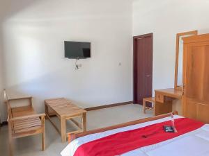 a bedroom with a bed and a tv on the wall at RedDoorz Resort near Darajat Garut in Garut