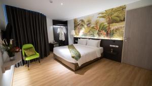 a bedroom with a bed and a painting on the wall at Pannarai Hotel Bangkok in Bangkok