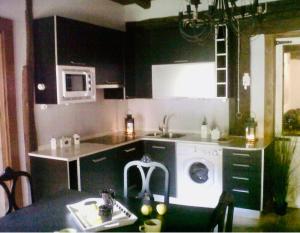 a kitchen with a sink and a washing machine at Casa Mayor in Gordexola