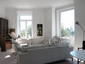 a living room with a white couch and windows at ApartmentInCopenhagen Apartment 1280 in Copenhagen