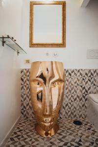 Una máscara de oro sentada en un suelo en un baño en RHome Business Collection Trevi, en Roma