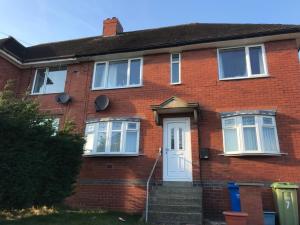 una casa de ladrillo rojo con puerta blanca en Dryden House, en Chesterfield