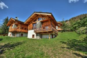 ein großes Holzhaus mit Balkon auf einem Hügel in der Unterkunft Chalet ALPACA Peisey-Vallandry - Domaine Paradiski in Peisey-Nancroix