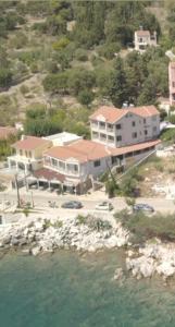 an aerial view of a house next to the water at Poseidon Apartments in Ayia Evfimia