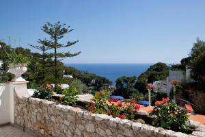 a stone retaining wall with flowers in a garden at Hotel La Floridiana in Capri