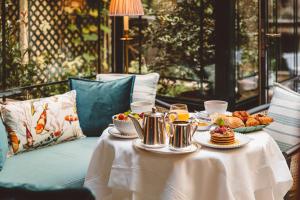 einen Tisch mit Speisen und Getränken oben in der Unterkunft Hôtel de l'Abbaye in Paris