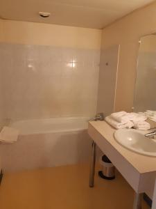 een badkamer met een wastafel en een bad bij Hotel les forges in Noyal-sur-Vilaine