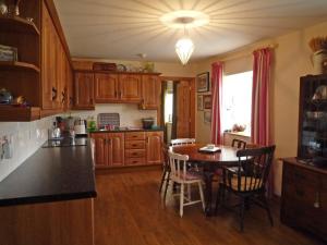 a kitchen with a table and a dining room at Little Irish Cottage in Carrick