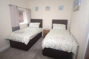 a bedroom with two beds and a window at No 28B St Benedict in Glastonbury