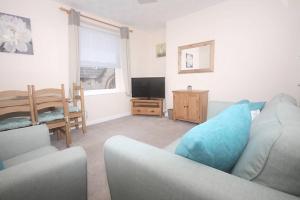 Una sala de estar con un sofá y un televisor. en No 28B St Benedict, en Glastonbury