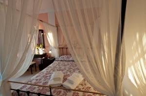 a bedroom with a canopy bed with white curtains at Artemis Village in Karterados
