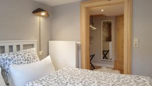 クヴェードリンブルクにあるFerienhaus Tor zum Münzenbergのベッドルーム(白いベッド1台、冷蔵庫付)