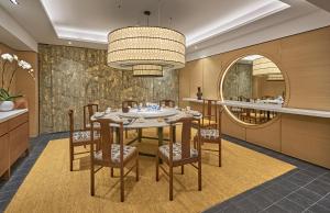 a dining room table with chairs and a large mirror at Goodwood Park Hotel in Singapore