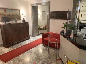 a living room with a red chair and a counter at Hotel Croce Di Malta in Rome