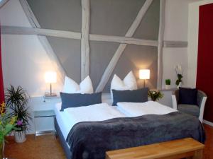 a bedroom with a large bed and two chairs at Pension "Westphal's" in Wismar