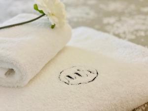 a white towel with a flower on top of it at Le Moulin de Rudelle in Muret