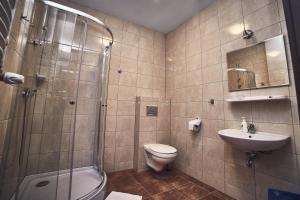 a bathroom with a toilet, sink, and shower at Hotel AB in Tychy