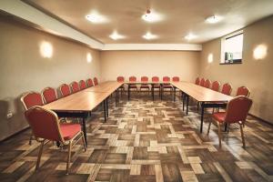 uma sala de conferências com mesas de madeira e cadeiras vermelhas em Hotel AB em Tychy