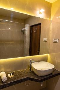 a bathroom with a sink and a mirror at Hotel Pratham in Solapur