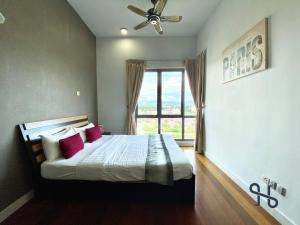 um quarto com uma cama com almofadas vermelhas e uma janela em Homesuite' Home at The Loft em Kota Kinabalu