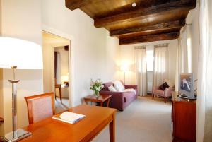 ein Wohnzimmer mit einem Tisch und einem Sofa in der Unterkunft Hotel Antico Podere Propano in Saluzzo