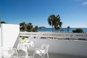 a balcony with a table and chairs and the beach at Magalluf Strip Apartment in Magaluf