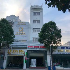 a tall white building with signs on it at Dung Khanh Motel in Dĩ An