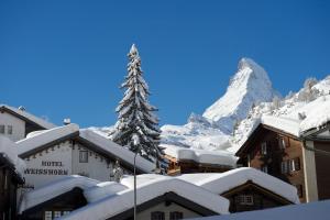 a resort with a snow covered mountain in the background at Hotel Weisshorn in Zermatt